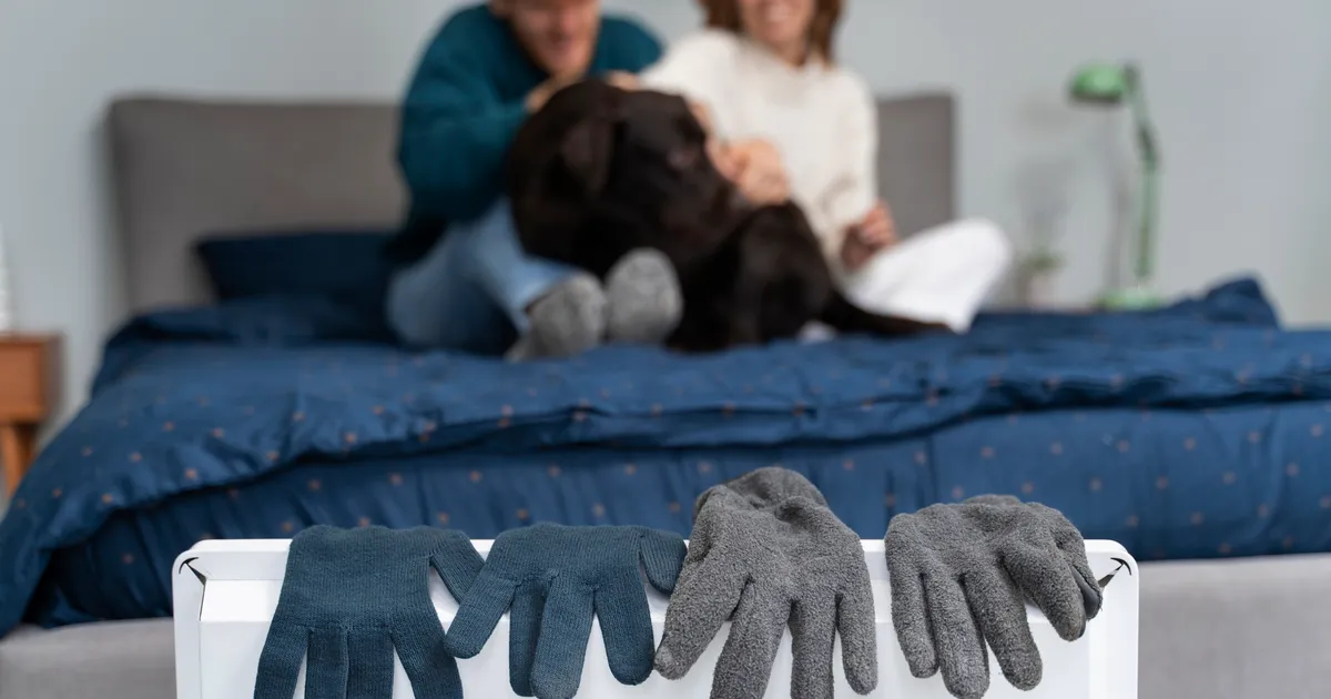 Pareja con guantes en el radiador durante un apagón de invierno — calefacción de emergencia en casa