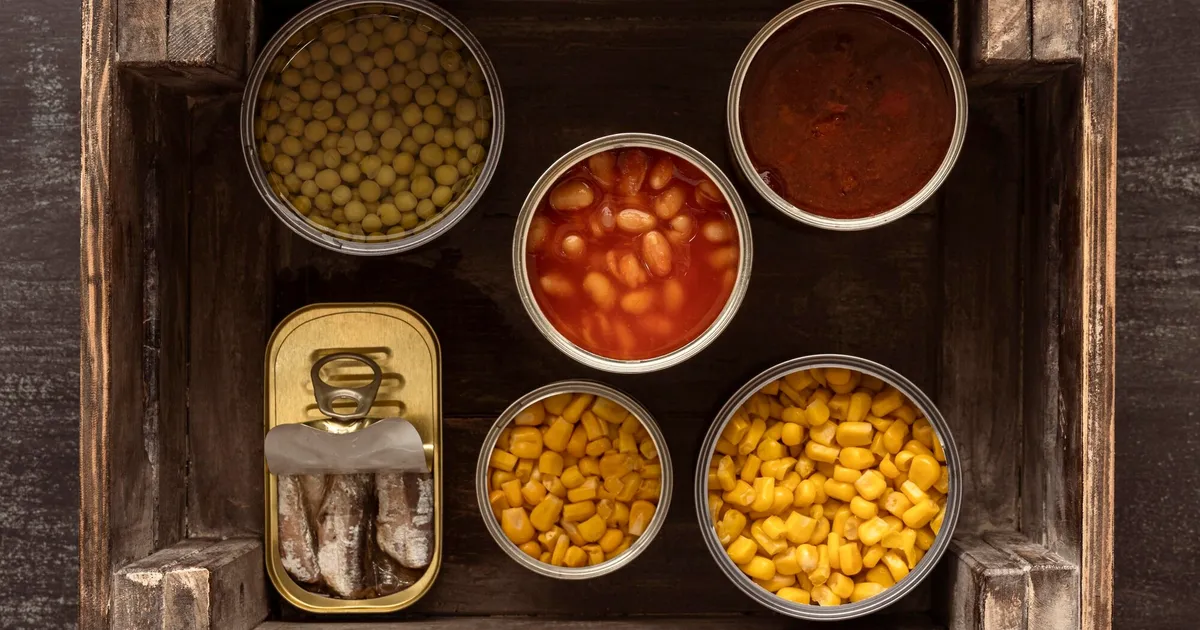 Latas de comida conservada en caja de madera para emergencias de larga duración