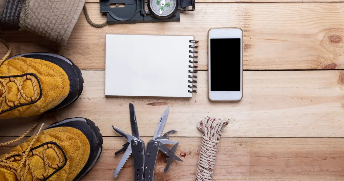 Equipo de supervivencia y material de emergencia organizado sobre mesa de madera para preparar un kit de 72 horas