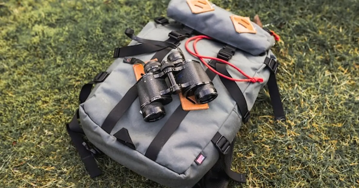 Mochila de supervivencia con equipo de emergencia sobre hierba al aire libre