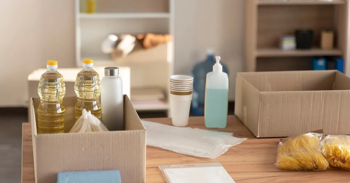 Equipo de supervivencia y senderismo organizado sobre superficie de madera con mochila, linterna y herramientas de emergencia