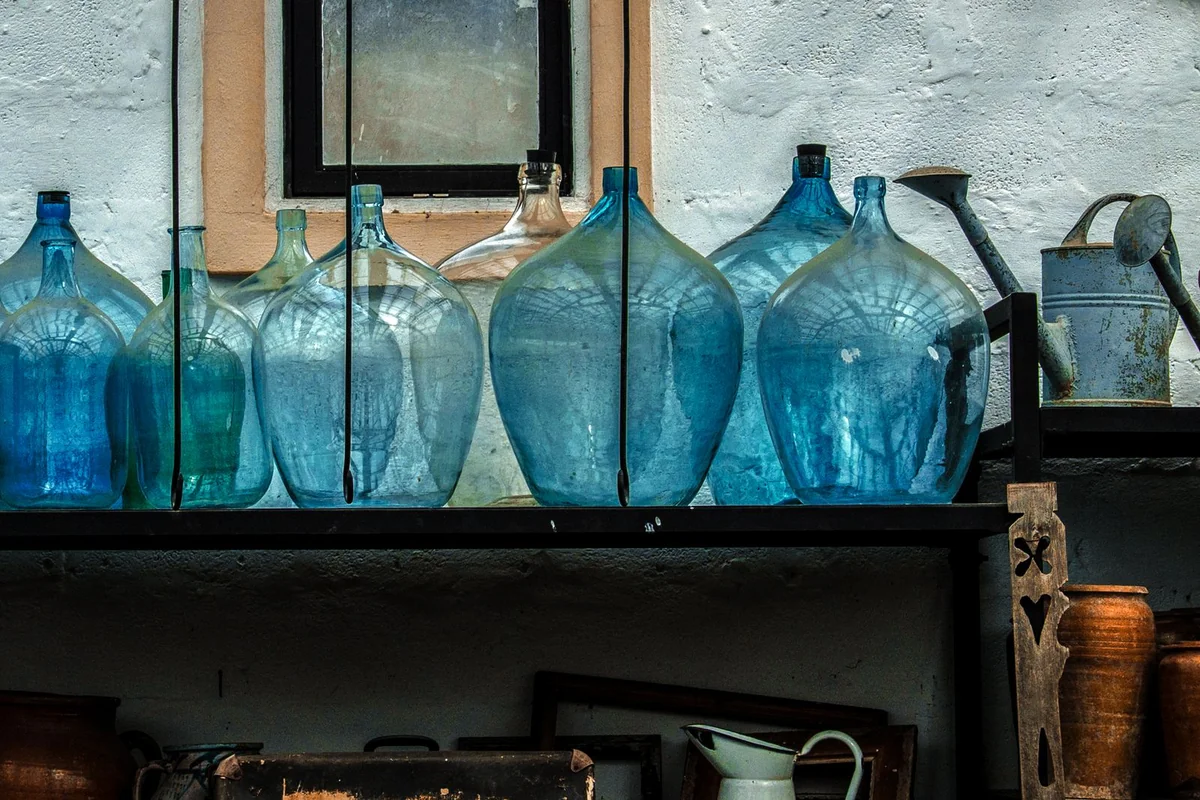 Despensa organizada con botellas y garrafas de agua almacenadas